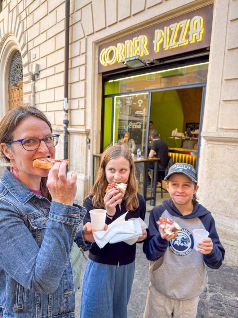 Celine Brewer, owner of 55StillAlive.com, enjoys pizza with her kids on a Rome street food tour.