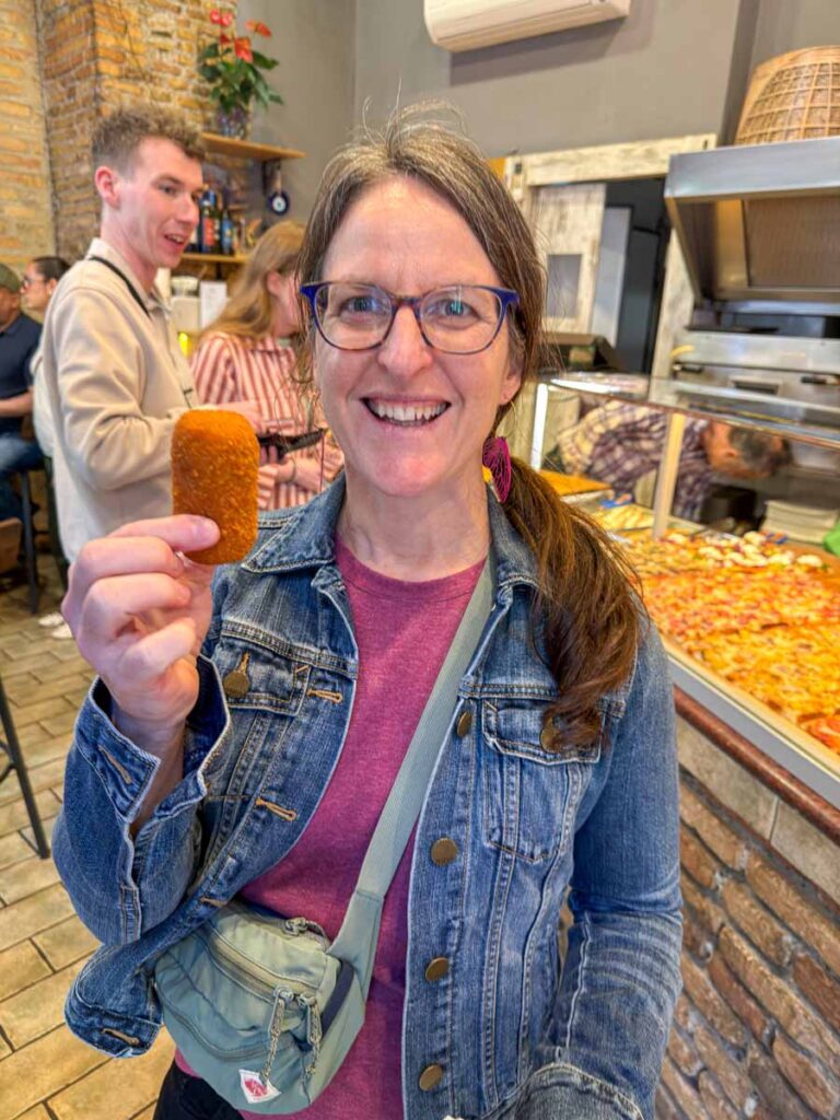 Celine Brewer holding supplì during a Rome street food tour.
