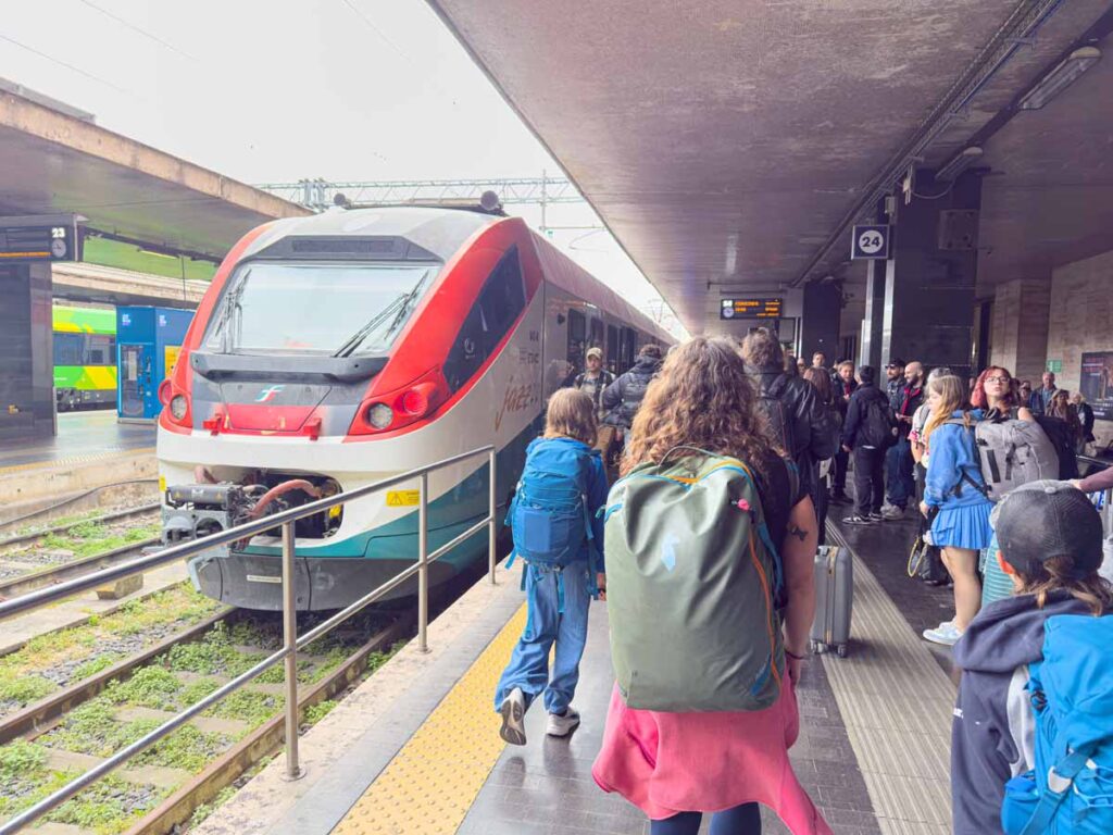 Travellers with luggage boarding a train at Roma Termini in Rome.